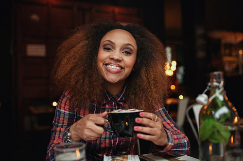 Young woman drinking coffee at cafe
