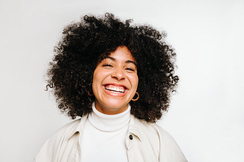 Gorgeous young woman with curly hair smiling at the camera