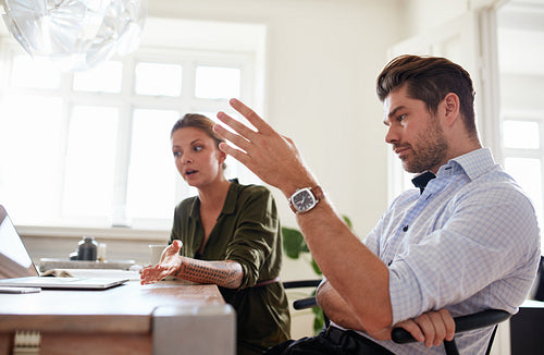 Young couple at home office discussing work