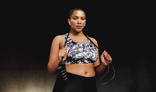 Fitness woman relaxing outdoors holding a skipping rope