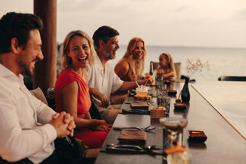 Friends enjoying a beachfront dinner during a warm evening at a resort