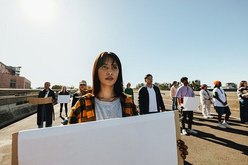 Group of activists demonstrating outdoors and holding blank signs for their cause