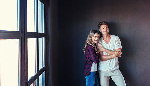Beautiful young couple standing together indoors