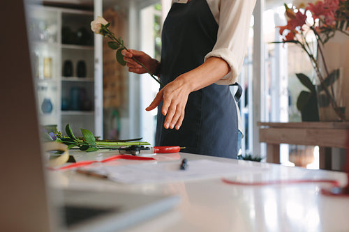 Florist making bouquet with flowers on counter