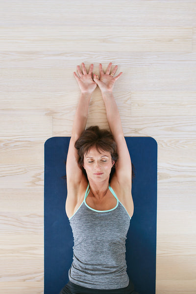 Fitness woman relaxing on yoga mat