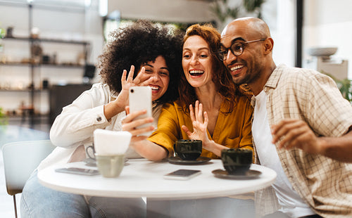 Friends in a cafe using a smartphone for a video call