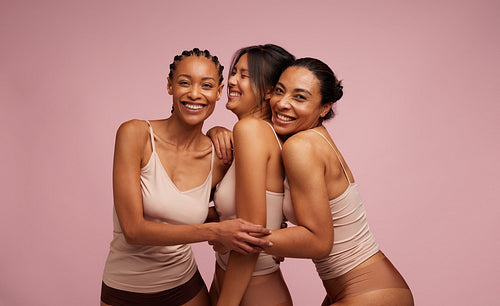 Multi-ethnic females in lingerie laughing together