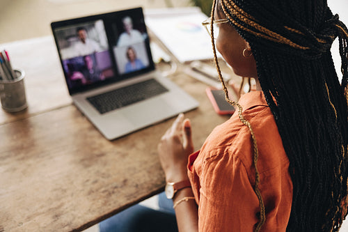 Graphic designer attending a virtual meeting at her desk