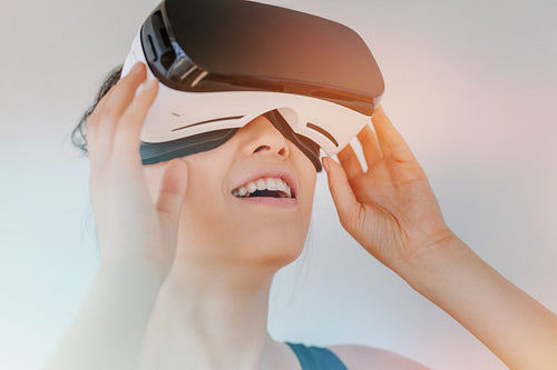 Young woman in virtual reality headset looking at objects
