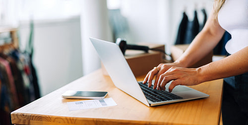 Online business owner using a laptop in her shop