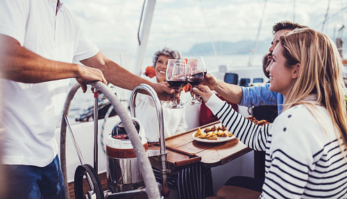 Woman on yacht toasting wine with her friends