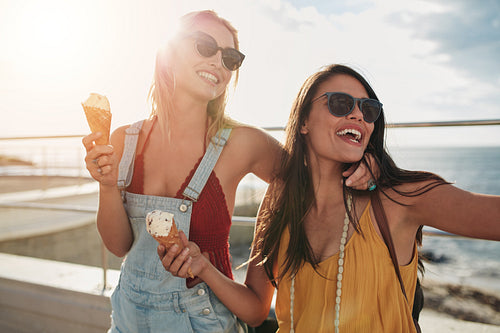 Two female friends enjoying ice cream together on a summer's day
