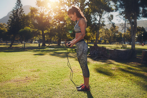 Fit young woman with skipping rope outdoors at the park