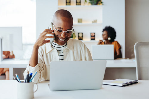 Cheerful businesswoman on a call with laptop at office