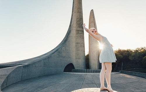 Female ballet dancer practicing dance moves on a rock
