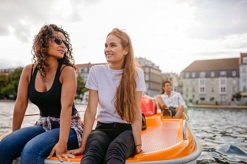 Teenage women sitting on pedal boat
