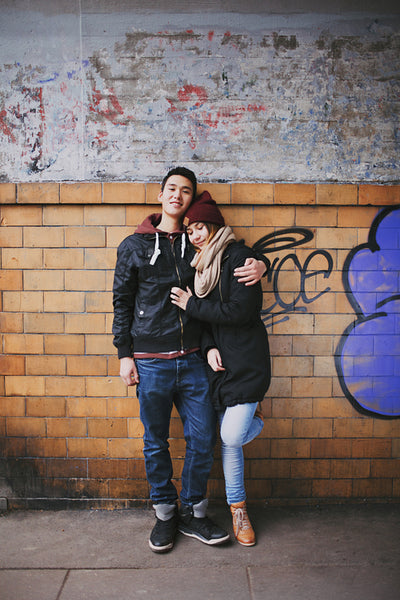 Affectionate couple embracing against a wall