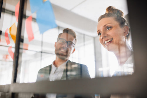 Two professionals looking over adhesive notes