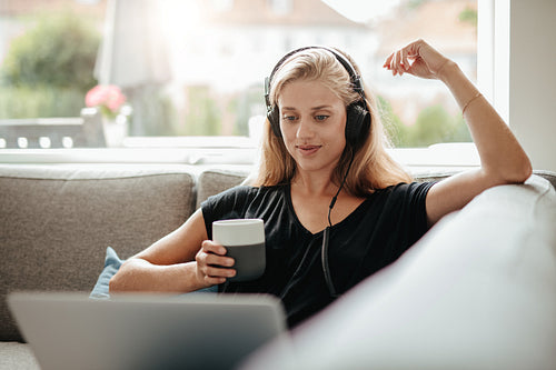 Beautiful woman with a cup of coffee and looking at laptop