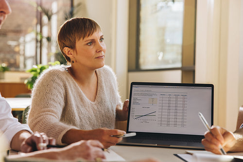 Businesswoman giving presentation on laptop in meeting