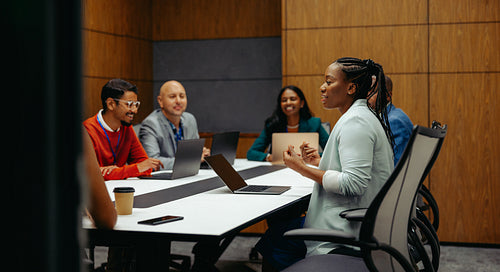 Confident African businesswoman speaking at a team meeting