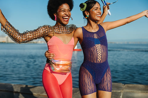 Two friends celebrate carnival by the water.