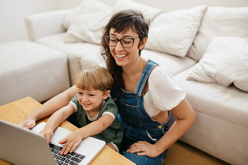 Smiling woman and son with laptop