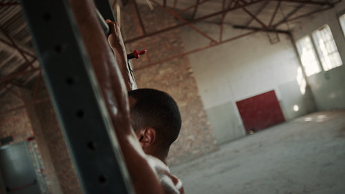 Strong man doing pull ups on horizontal bar in gym