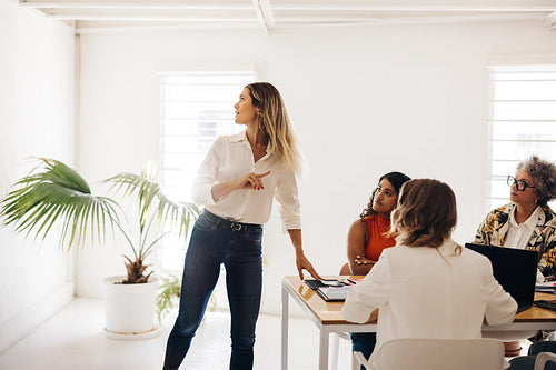 Team leader sharing her ideas with her colleagues in an office