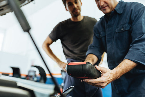 Mechanics using a device for checking engine