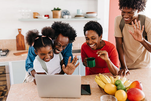 Family connecting with loved ones on a video call: Daily routine with smiling parents and kids