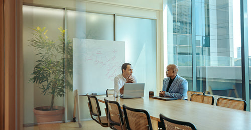 Aesthetic workplace meeting in modern office with two male professionals discussing business strategies