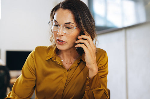 Businesswoman discussing ideas over a phone call in her office