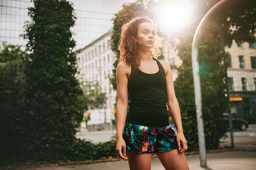 Attractive young girl standing on basketball court