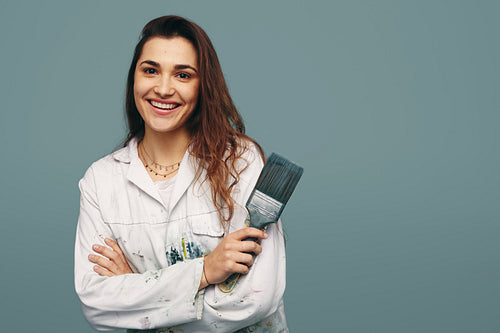 Cheerful female painter smiling at the camera in a studio