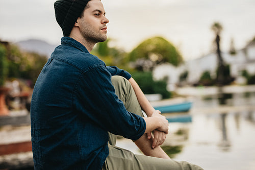 Man sitting beside a lake and relaxing