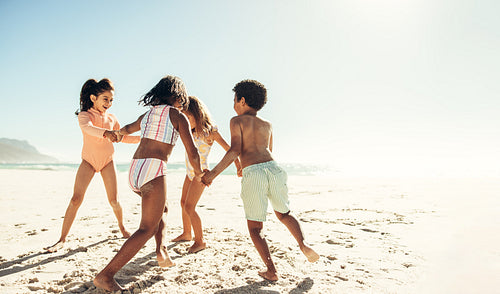 Happy young friends playing a game at the beach