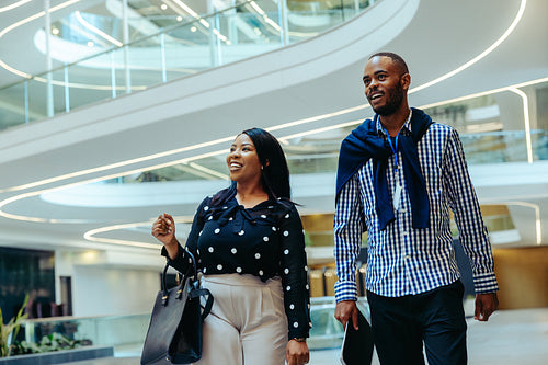 Two coworkers walking in a contemporary business building in the financial district
