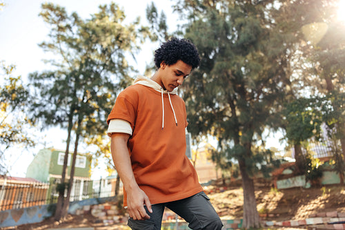 Sporty teenage boy playing with his skateboard in an urban park