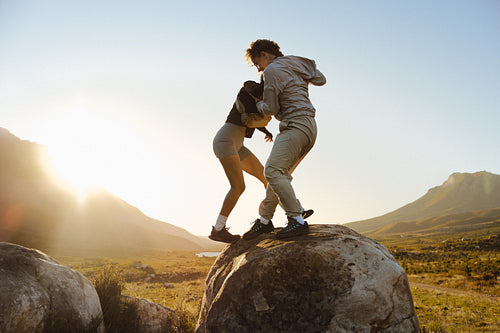 Couple climbing rocks in breathtaking landscape