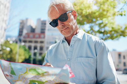 Mature tourist consulting a map while touring a foreign city