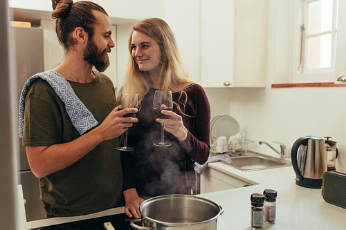 Happy couple at home enjoying wine