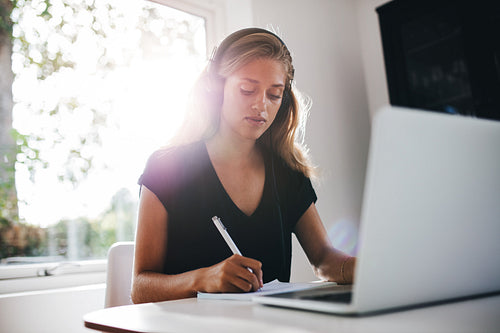 Young woman studying in kitchen