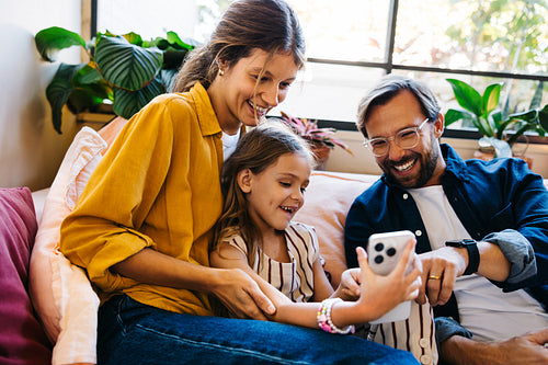 Family smiles as parents and daughter share a video call