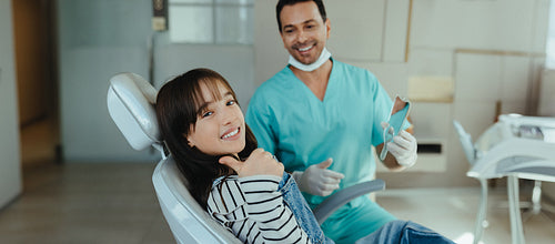 Happy child patient gives a thumbs up in friendly clinic