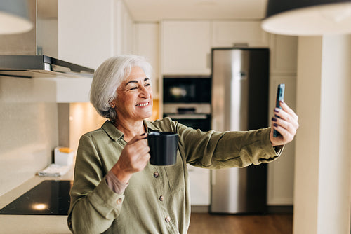 Grey-haired senior woman making a video call on her smartphone