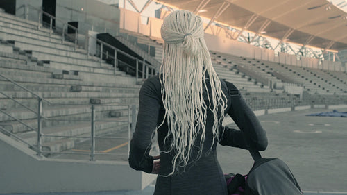 Female athlete arriving at stadium for practice
