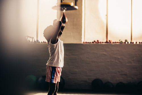 Kids boxer relaxing with his hands on forehead