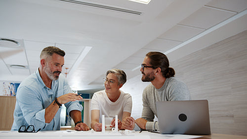 Engineering experts discussing a windmill design in an office