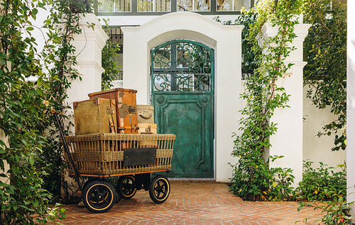 Cart full of travelling bags placed outside a hotel